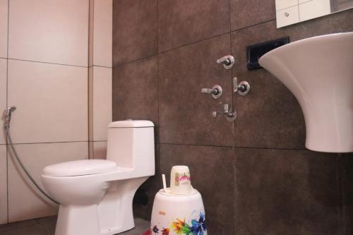 a bathroom with a toilet and a sink at Hotel Wayanad Stay in Kalpetta