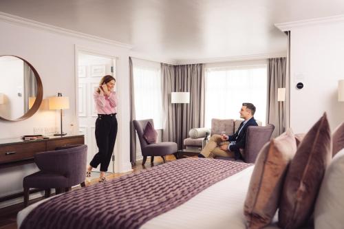 a woman talking on a cell phone in a hotel room at Ivanhoe Inn and Hotel in Belfast