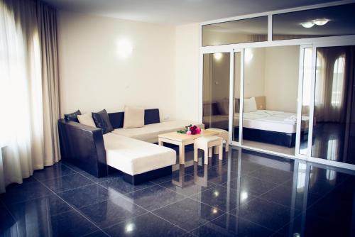 a living room with a couch and a table at Apart Hotel Apolonia Palace in Sinemorets