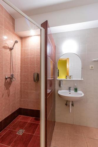 a bathroom with a sink and a shower at Kisduna Étterem-Panzió in Dunaharaszti