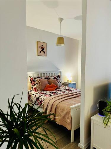 um quarto com uma cama e um vaso de plantas em Apartament blisko centrum Warszawy em Varósvia
