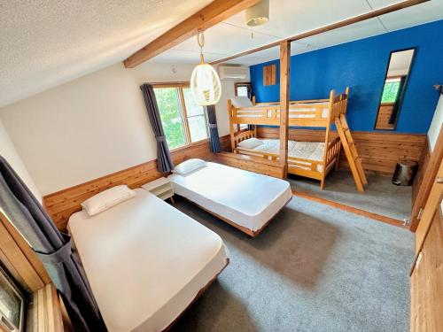 白馬村にあるMoment Chalet Hakubaのベッドルーム(ベッド2台、ベビーベッド1台付)