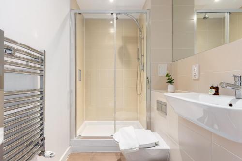 a bathroom with a shower and a toilet and a sink at The Hackney Studio Apartments in London