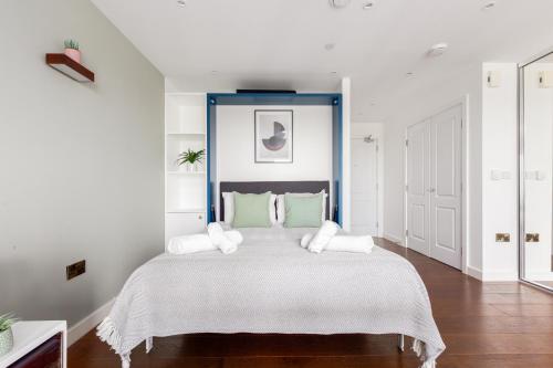 a bedroom with a large bed with a blue headboard at The Hackney Studio Apartments in London