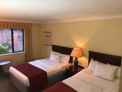 ein Hotelzimmer mit 2 Betten und einem Fenster in der Unterkunft Urban Hotel in Grantham