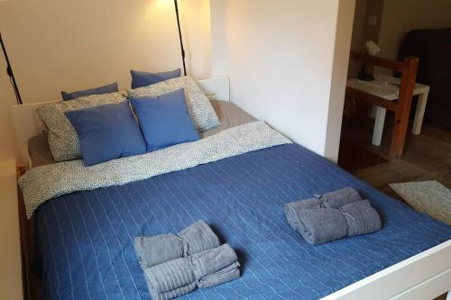 uma cama com almofadas azuis e toalhas em Apartament, ogródek, przy Rynku! em Zielona Góra