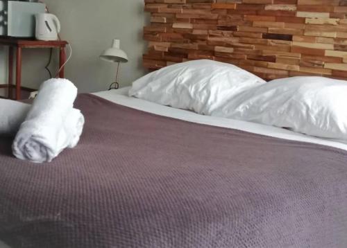 uma cama com lençóis brancos e almofadas em OLOO Habitat - Le19 - Parking Privé em Montbéliard