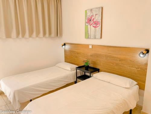 a room with two beds and a table at Seaview Canteras in Las Palmas de Gran Canaria