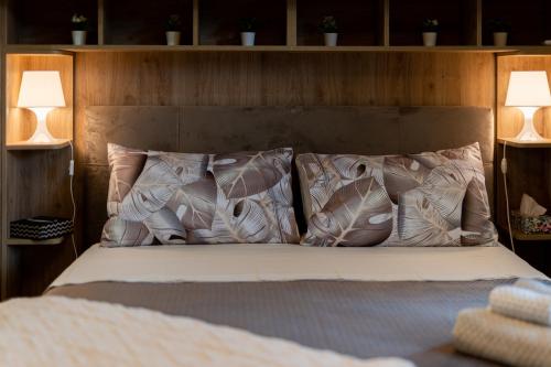 a bed with pillows on it with two lamps at Le fantasie di Tizi in Alpignano
