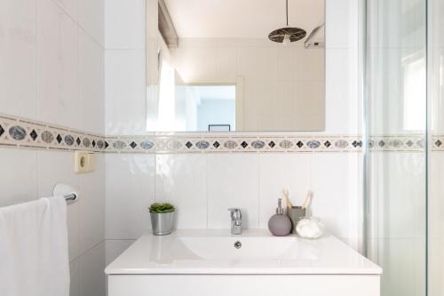 a white bathroom with a sink and a mirror at Senel Home in Boimorto