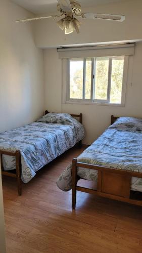 um quarto com 2 camas e uma ventoinha de tecto em Neuquén Center Apartamentos em Neuquén