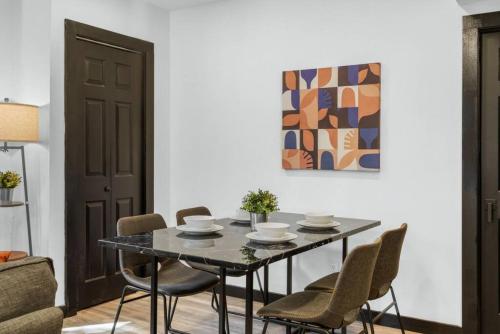 a dining room with a black table and chairs at Charming 2BR Philadelphia Retreat with Free Parking in Philadelphia