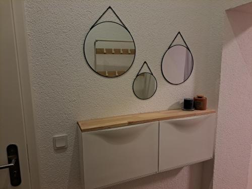 a bathroom with two mirrors on the wall at Gemütliche Wohnung mit Garten in Horn-Bad Meinberg