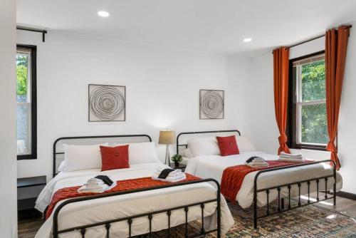 two beds in a bedroom with white walls and windows at Cozy 2BR,1BA Retreat for 6 with Free Parking in Philly in Philadelphia