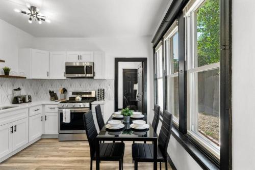 a kitchen with a black table and chairs in it at Stylish 3BR Philly Retreat with Free Parking in Philadelphia