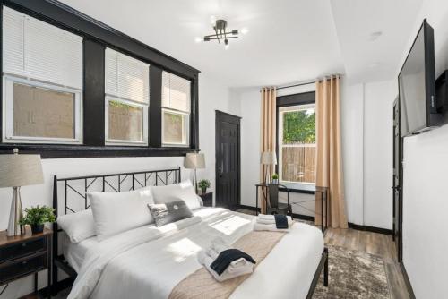 um quarto com uma grande cama branca e janelas em Modern City Luxury Home with Ample Parking in Charming Philly! em Filadélfia