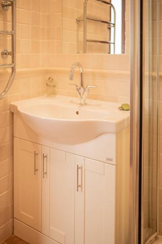 a bathroom with a white sink and a shower at Casa Pedro in Salema - Oceanview & beach in Salema