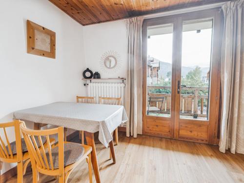 une salle à manger avec une table et des chaises et une fenêtre dans l'établissement Studio cosy avec balcon et piscine à Serre Chevalier, à 300m des pistes - FR-1-762-11, à Saint-Chaffrey