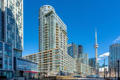 a tall glass building in front of a city at City Serenity 1 Bedroom with Balcony in Toronto