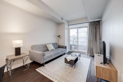 a living room with a couch and a tv at City Serenity 1 Bedroom with Balcony in Toronto