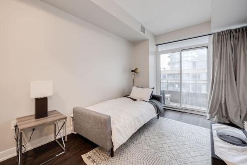 a bedroom with a bed and a large window at City Serenity 1 Bedroom with Balcony in Toronto