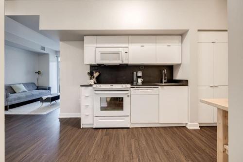 a kitchen with white appliances and a living room at City Serenity 1 Bedroom with Balcony in Toronto