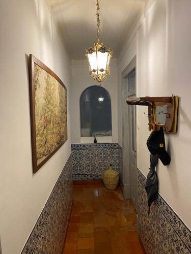 a hallway with a painting on the wall and a chandelier at Pátio da Villa - Coruche Boutique Guest House in Coruche