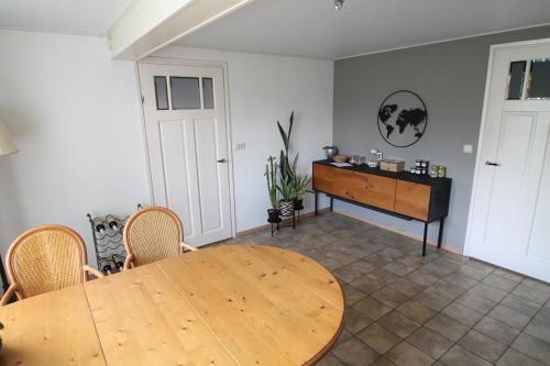 a dining room with a wooden table and a desk at Karin's kruidenhoeve B&B kamer Kamille met Finse sauna in Lutten