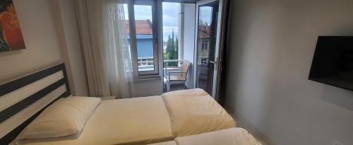 um quarto com uma cama e vista para uma varanda em MEYDAN BUTİK OTEL em Tekirdağ