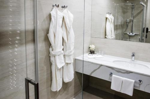 a white bathroom with a sink and a mirror at Nadiya Palace in Ivano-Frankivsʼk