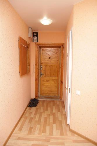 pasillo con puerta de madera en una habitación en студия на пр.Пушкина 1, en Dnipro