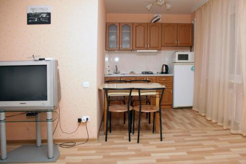 cocina con mesa con sillas y TV en студия на пр.Пушкина 1, en Dnipro