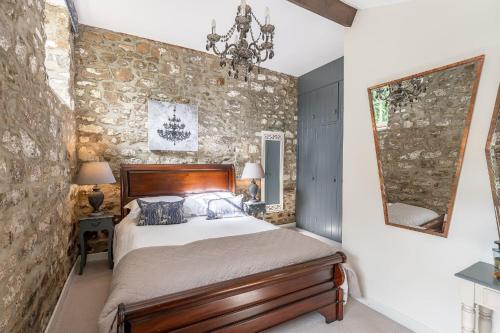 - une chambre avec un lit et un mur en pierre dans l'établissement Sun Hill Palins, à Leyburn