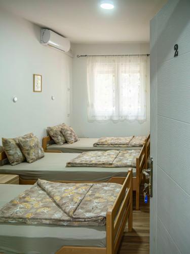 a group of four beds in a room at Sobe Marija in Kikinda