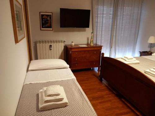 una camera con due letti e una TV a parete di Le Stanze di Nonna Lina a Pagani