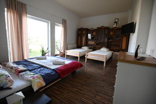ein Wohnzimmer mit einem Bett und einem großen Fenster in der Unterkunft Julianna Vendégház Étterem, Rendezvényhelyszín és Szállás 