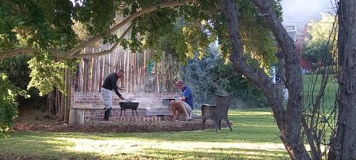 two men sitting on a bench in a park at Willow's Rest in Barrydale