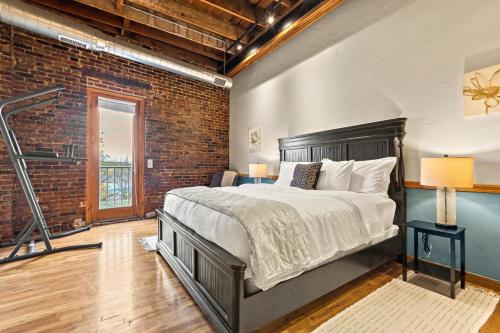 um quarto com uma cama e uma parede de tijolos em Railway Retreat in Downtown em Springfield