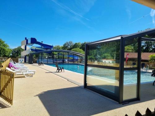 une grande piscine avec toboggan dans une aire de jeux dans l'établissement Mobil Home cosy 5 personnes proche du Puy Du Fou, à La Boissière-de-Montaigu