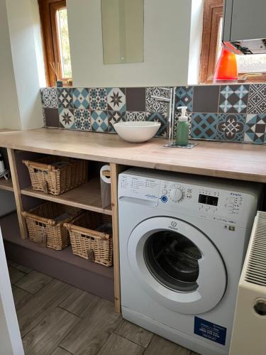 a kitchen with a washing machine under a counter at Our Place In Portland Holiday Home with Sea View in Portland