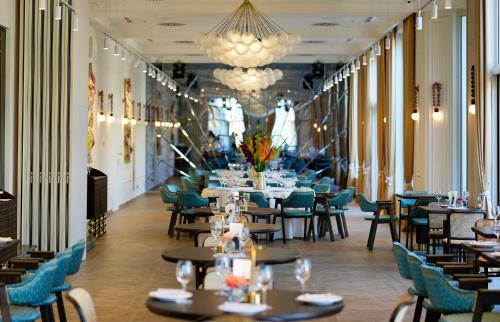a dining room with tables and chairs and a chandelier at Nadiya Palace in Ivano-Frankivsʼk