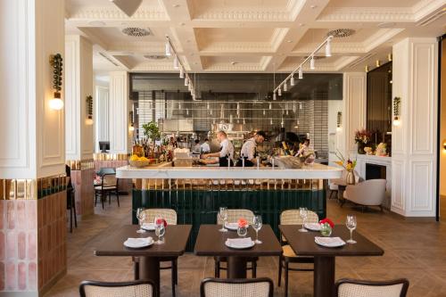 a restaurant with tables and a counter with people in the kitchen at Nadiya Palace in Ivano-Frankivsʼk