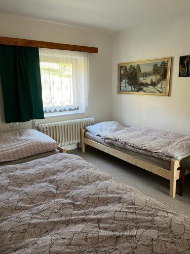 1 dormitorio con 2 camas y ventana en Venkovský dům Horní Bečva en Horní Bečva