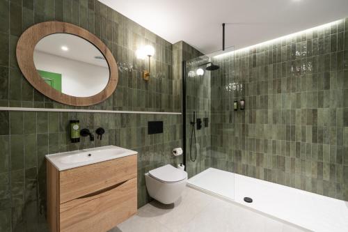 bagno con servizi igienici, lavandino e specchio di Ivanhoe Inn and Hotel a Belfast