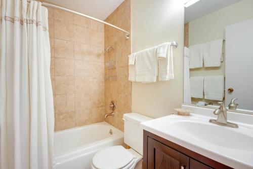 a bathroom with a sink and a toilet and a tub at Cozy Condo with Balcony - Near Big Sky Resort! in Big Sky