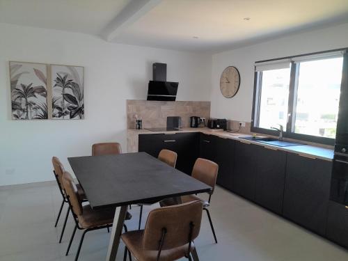 une cuisine et une salle à manger avec une table et des chaises dans l'établissement Domaine d'Arca - Flaubert 22 - 3 pièces - étage 2 - Porto-Vecchio, à Porto-Vecchio