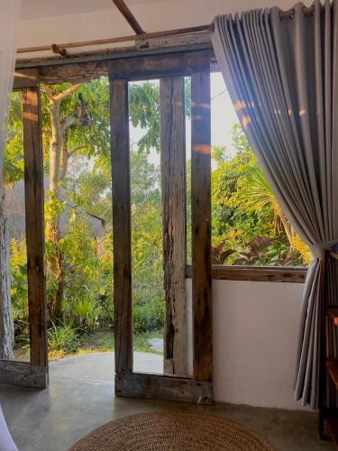 an open window in a room with a curtain at Vertical House Bali in Uluwatu