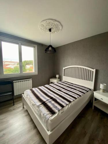 - une chambre avec un lit blanc et 2 fenêtres dans l'établissement Appartement Royan Pontaillac Métairie, à Royan