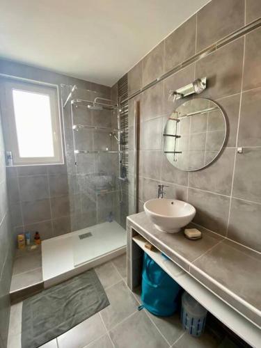 une salle de bain avec un lavabo et un miroir dans l'établissement Appartement Royan Pontaillac Métairie, à Royan