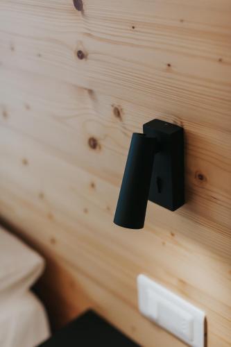 a black object hanging on a wooden wall at Falcade Lodge in Falcade